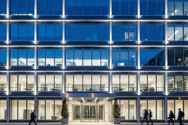 A modern office building facade lit with crisp daylight white light